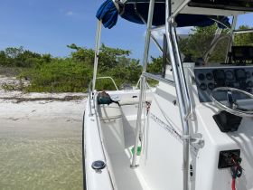 A detailed view of the helm and seating area inside a boat, showcasing the controls and comfortable seating, perfect for navigating the waters.