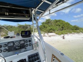 A detailed view of the helm and console area inside a boat, showcasing navigation equipment and controls, perfect for those interested in boating technology.