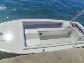 An interior view of a sleek boat showcasing its seating and console area, perfect for a day on the water.