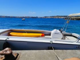 A view of the interior of a boat featuring a yellow kayak and console, perfect for water adventures and exploring coastal areas.