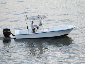 A speedboat navigates the water with a captain at the helm, showcasing the thrill of boating adventures.