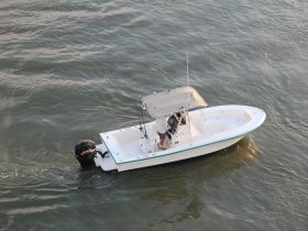 A center console boat is seen underway on the water, showcasing its sleek design and functionality for fishing or leisure activities.
