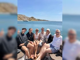 A cheerful group of friends enjoys a sunny day on a boat, capturing the essence of fun and camaraderie on the water.