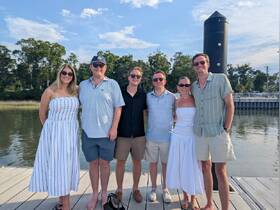 A cheerful group poses together on the dock, ready for a fun day on the water — perfect for gatherings and celebrations.