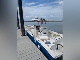 A sleek speedboat docked at the marina, showcasing its spacious seating and helm area, perfect for a day on the water.