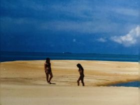 Two girls explore a sandy beach at a picturesque sandbar, enjoying a fun day in the sun — a perfect backdrop for memorable beach adventures.