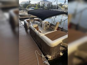 Interior view of a spacious pontoon boat featuring comfortable seating and a well-equipped helm, perfect for leisurely outings on the water.