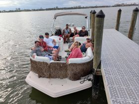 A lively group enjoys a day on a pontoon boat, showcasing camaraderie and fun on the water — perfect for summer outings and celebrations.