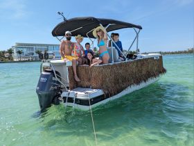 A joyful family poses on their boat, enjoying a sunny day on the water — perfect for creating lasting memories and fun adventures.