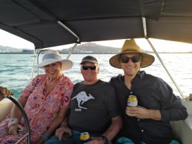 A cheerful group enjoys a relaxing moment on a boat, sharing drinks and smiles against a scenic backdrop — perfect for memorable outings on the water.