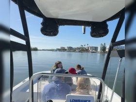 A group of friends enjoys a scenic boat ride, capturing the essence of a relaxing day on the water with picturesque views in the background.