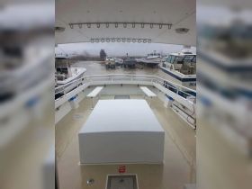 A view of the interior helm area of a boat, showcasing the spacious layout and seating arrangements, ideal for navigation and comfort.