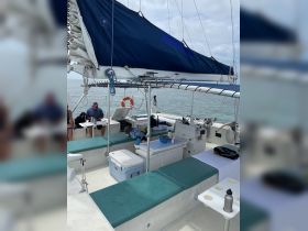 Inside view of a spacious catamaran featuring comfortable seating and a helm area, with guests relaxing onboard — perfect for a day of sailing adventures.