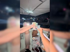 A lively group toasts with colorful cocktails aboard a boat at night, capturing the essence of celebration and camaraderie on the water.