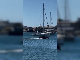 A picturesque view of sailboats docked in the harbor, showcasing the serene boating atmosphere against a clear blue sky.