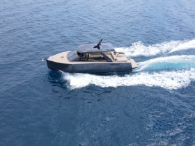 An aerial view of a sleek yacht cruising through deep blue waters, showcasing its modern design and elegance — perfect for luxury charters and ocean adventures.
