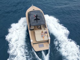 A woman relaxes on the deck of a luxury boat as it cruises through the open water, showcasing the perfect blend of relaxation and adventure.