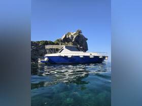 A striking view of a boat anchored near a rocky coastline under a clear blue sky, perfect for showcasing marine adventures and scenic getaways.