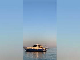 A serene view of a yacht docked on calm waters, showcasing its sleek design against a clear sky — perfect for a relaxing day on the water.