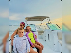 A joyful family enjoys a boat ride at sunset, creating lasting memories on the water with smiles and laughter.