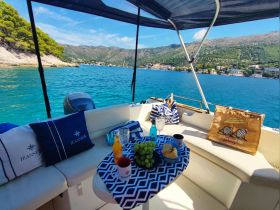 A beautifully arranged table on a boat featuring drinks, snacks, and a scenic view — perfect for a relaxing day on the water.