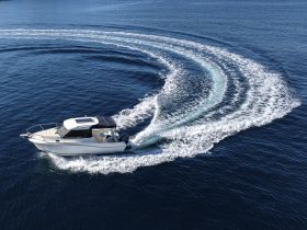 An aerial view of a speedboat making sharp turns in open water, showcasing its agility and performance on the waves.