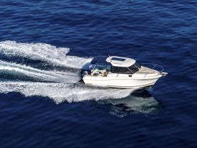 A stunning aerial view of a speedboat cruising through deep blue waters, showcasing its sleek design and dynamic movement.