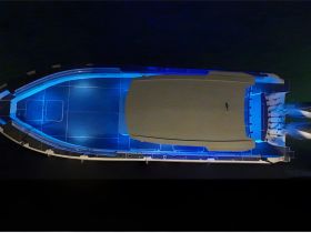 Aerial view of a beautifully lit boat showcasing its sleek design and structure, perfect for evening cruises or nighttime adventures on the water.
