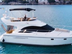 A stunning aerial view of a luxurious yacht cruising through clear waters, showcasing its elegant design and perfect for upscale boating experiences.