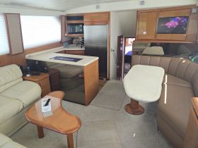 Interior view of a spacious boat cabin featuring comfortable seating and a well-equipped galley, perfect for relaxing and entertaining while on the water.