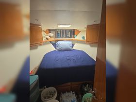 Cozy cabin interior featuring a comfortable bed and storage, ideal for restful nights on the water.