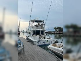 A pristine view of the 'Triple Net' fishing yacht docked at the marina, showcasing its sleek design and fishing gear, perfect for charter adventures in Charleston, SC.