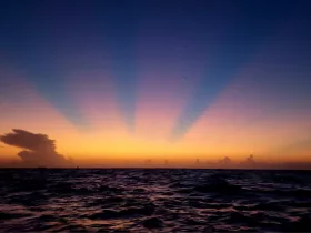 A breathtaking sunset over the ocean, showcasing vibrant colors and serene waves — a perfect backdrop for evening boat trips and romantic getaways.