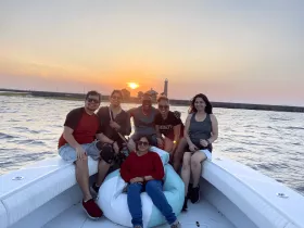 A cheerful group enjoys a sunset boat ride, capturing the perfect moment of camaraderie against a stunning backdrop.