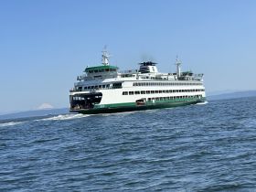 A Washington State ferry navigates through calm waters, showcasing its sleek design and providing essential transportation across the scenic landscape.