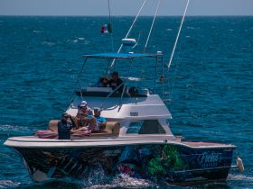 A lively group enjoys a day on the water aboard a colorful boat, showcasing the fun and excitement of on-water activities.