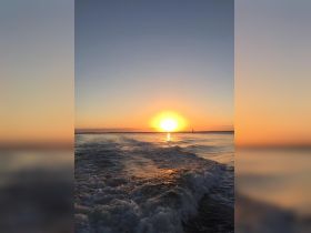 A stunning sunset over calm waters, capturing the beauty of a serene boating experience — perfect for sunset cruises.