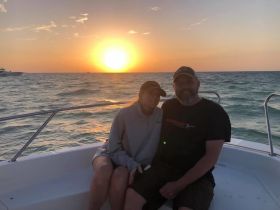 A couple enjoys a romantic sunset on a boat, creating a perfect backdrop for memorable moments on the water.