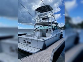 A stunning view of the 'Sea Time' yacht docked at the marina, showcasing its sleek design and spacious layout, perfect for exploring the Cayman Islands.