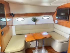 Cozy interior of a boat featuring a comfortable seating area and dining table, perfect for relaxing and enjoying meals while on the water.