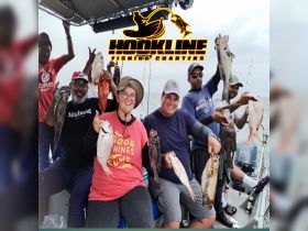 A joyful group displays their impressive catch during a fishing charter, showcasing the excitement of a successful day on the water.