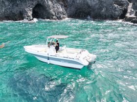 A sleek speedboat named 'White Shark' navigates through crystal-clear waters, showcasing the perfect vessel for thrilling adventures on the sea.