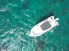 Aerial view of a sleek speedboat gliding through crystal-clear turquoise waters, perfect for adventurous outings or island hopping.