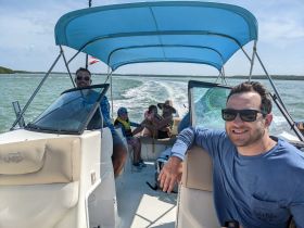 A joyful family enjoys a boat ride, with kids and adults sharing smiles and laughter on a sunny day — perfect for creating lasting memories on the water.