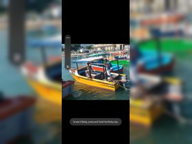 Two children interact on a colorful boat at the dock, showcasing a lively atmosphere perfect for family outings on the water.