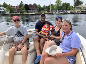 A joyful family enjoys a sunny day on the boat, creating lasting memories together on the water.