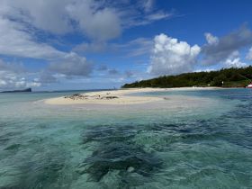 A stunning view of a secluded sandbar surrounded by clear turquoise waters, perfect for island hopping adventures and beach exploration.