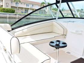 A stylish interior view of a boat's seating area, featuring plush cushions and a drink holder, perfect for relaxing on the water.
