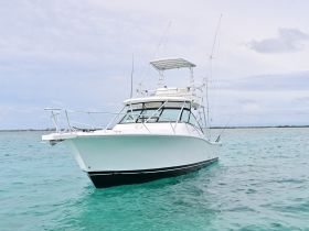 A sleek speedboat glides through clear turquoise waters, showcasing its elegant design and perfect for thrilling adventures on the sea.