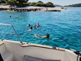 A group enjoys snorkeling in crystal-clear waters, showcasing the vibrant marine life and stunning scenery — perfect for adventure seekers and nature lovers.